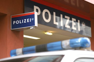 Viyana 'da polis aracının ön planında yanıp sönen ışıklar bulunan polis binası (Avusturya)