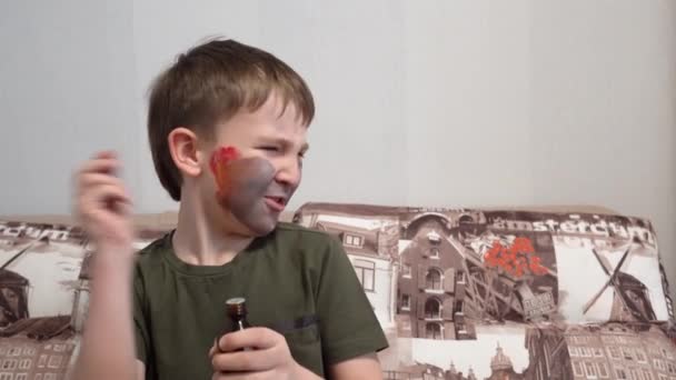 Jongen met gezicht verf ruiken een fles van de geneeskunde en Hamming — Stockvideo