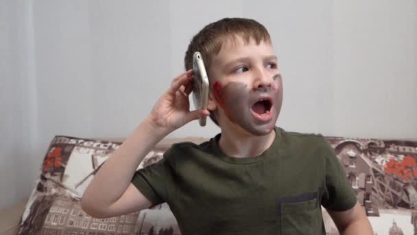 Garçon avec de la peinture sur le visage parler au téléphone, geste — Video