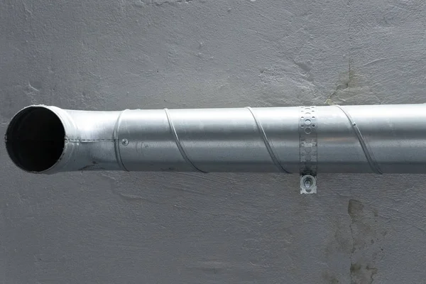 Graues Entlüftungsrohr wird an grauen Wandhalterungen an der Decke befestigt — Stockfoto
