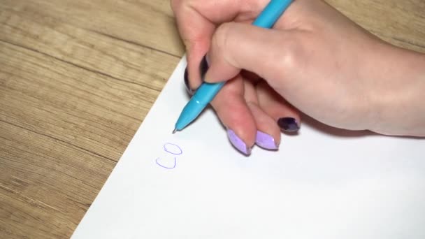 La mano de la muchacha con la manicura escribe sobre el papel covid-19 el primer plano — Vídeo de stock