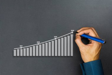 İşadamı grafik çizme yılı grafikleri çiziyor. Tarif et