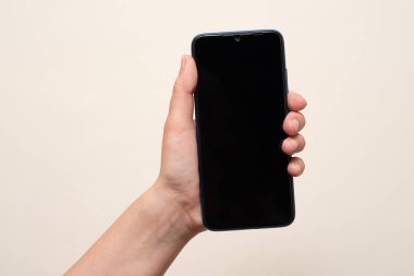 İç mekanda cep telefonu tutan bir kadın.
