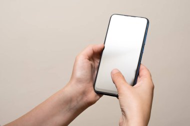 İç mekanda cep telefonu tutan bir kadın.