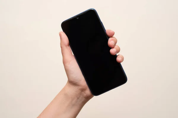 İç mekanda cep telefonu tutan bir kadın.