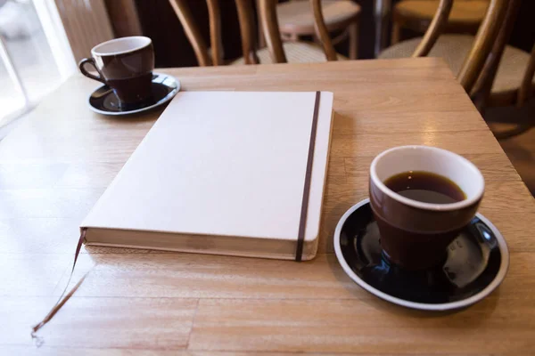 Bok Med Ett Tomt Omslag Och Två Svarta Kaffe Bordet — Stockfoto
