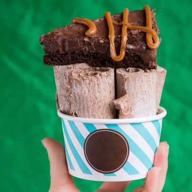 Yeşil arka planda karamel soslu dondurmalı kek.