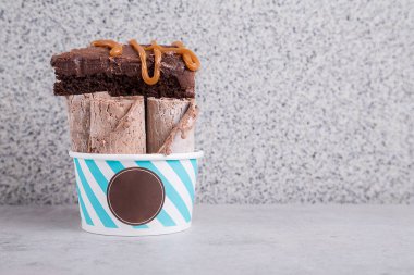 Gri arkaplanda karamel soslu dondurmalı kek.