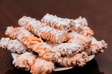 Tabakta duran pudra şekerli ev yapımı kurabiyeler. Ev yapımı kurabiyelerle bir fincan kahve.