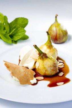 Marcaspone peynirli incirler, üzerine karamelize edilmiş badem dilimleri. İtalyan usulü lezzetli bir tatlı, beyaz bir tabakta servis edilir..