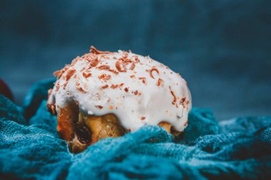Yumuşak bulanık mavi arka planda kremalı lezzetli bir pasta.