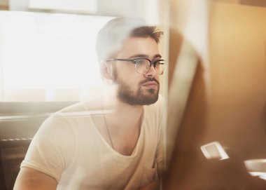 Mutlu genç adam, onun laptop g için çalışıyormuş gibi gözlük,