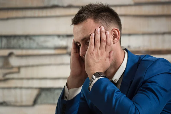 Uomo d'affari stanco sul posto di lavoro in ufficio tenendo la testa su ha — Foto Stock