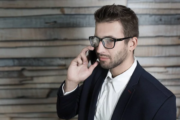 Economista maschio parlando al telefono cellulare mentre in piedi in moderatore — Foto Stock