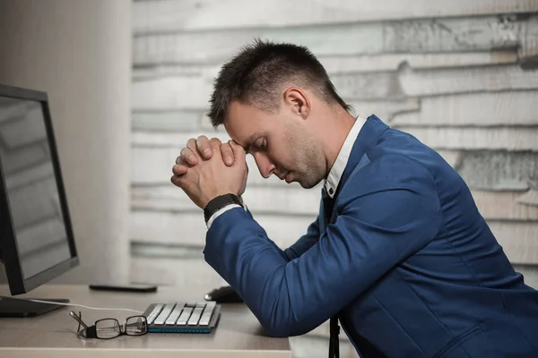 Uomo d'affari stanco sul posto di lavoro in ufficio tenendo la testa sulle mani. Lavoratore assonnato la mattina presto dopo il lavoro a tarda notte. Sovraccarico di lavoro, errori, stress, terminazione o depressione — Foto Stock