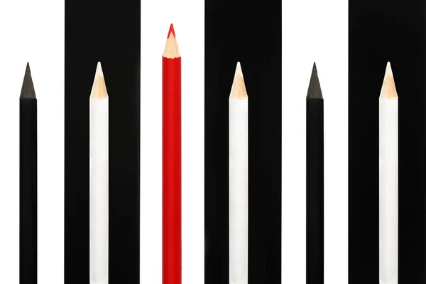 Red pencil standing out from crowd of black and white fellows on bw stripe background. business success concept of leadership uniqueness, independence, initiative, strategy, dissent, think different — Stock Photo, Image