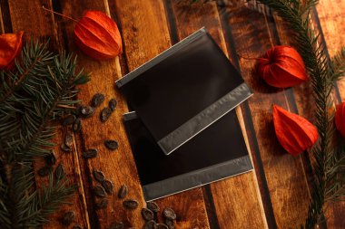 Fotoğraf çerçeve çubuk vintage ahşap doku üzerinde. Noel ve yeni yıl arka plan kavramı. Polaroid çerçeve retro tarzı tablo. çam dalları, turuncu kış kiraz ve kırmızı papyon