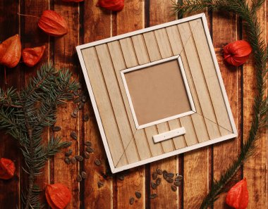 Fotoğraf çerçeve çubuk vintage ahşap doku üzerinde. Noel ve yeni yıl arka plan kavramı. Polaroid çerçeve retro tarzı tablo. çam dalları, turuncu kış kiraz ve kırmızı papyon