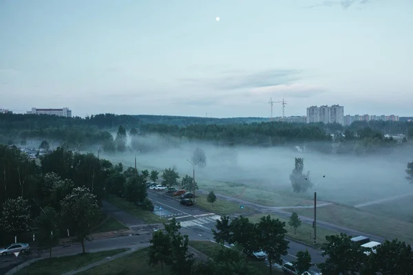 Paysage naturel le matin dans la ville par temps brumeux avec ciel spectaculaire et forêt. Le brouillard comme le smog — Photo