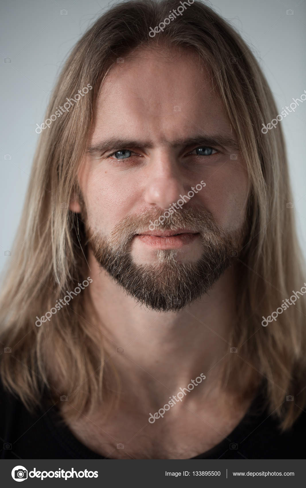 Portrait Of Man With Long Blond Hair Looking In Camera Closeup