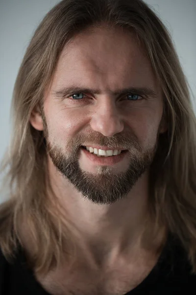 Retrato de homem com longos cabelos loiros olhando para a câmera. Retrato de perto do rapaz. Bull brutal com olhos incríveis e dentes brancos smilling — Fotografia de Stock