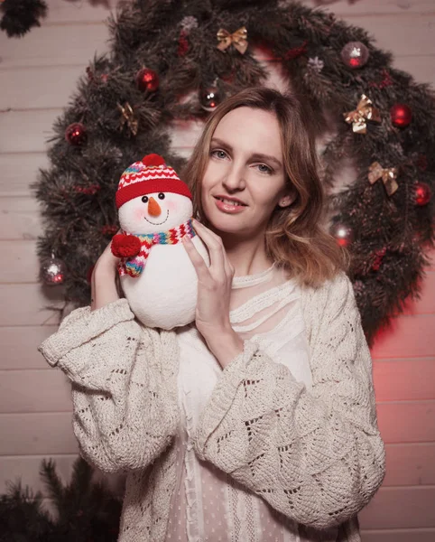 Neues Jahr junges Mädchen mit Feiertagsstimmung im weihnachtlichen Interieur mit Baum und lustigen Deko-Spielzeugen. schönes Frauenporträt in Pullover und Dekor in den Armen. freien Speicherplatz für Text kopieren. Trend 2017 — Stockfoto