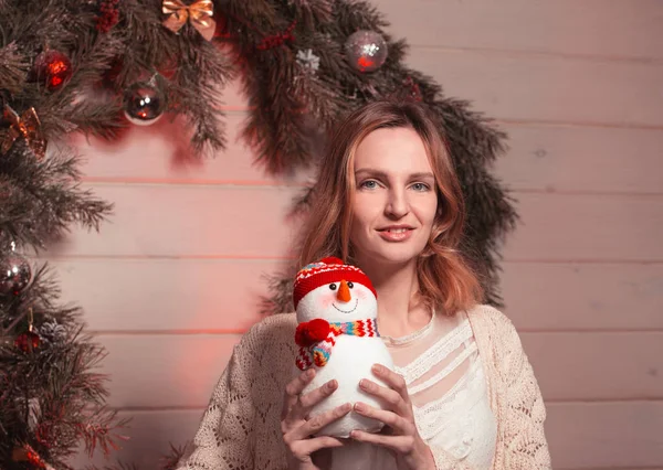 Neues Jahr junges Mädchen mit Feiertagsstimmung im weihnachtlichen Interieur mit Baum und lustigen Deko-Spielzeugen. schönes Frauenporträt in Pullover und Dekor in den Armen. freien Speicherplatz für Text kopieren. Trend 2017 — Stockfoto