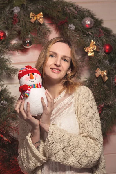 Neues Jahr junges Mädchen mit Feiertagsstimmung im weihnachtlichen Interieur mit Baum und lustigen Deko-Spielzeugen. schönes Frauenporträt in Pullover und Dekor in den Armen. freien Speicherplatz für Text kopieren. Trend 2017 — Stockfoto