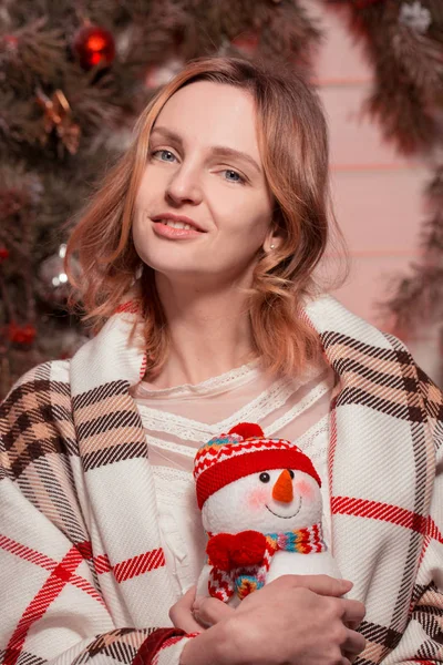 Nouvel An jeune fille avec humeur de vacances à l'intérieur de Noël avec arbre et jouets décoratifs drôles. Beau portrait de femme en pull et décor dans les bras. Copier l'espace libre pour le texte. Tendance 2017 — Photo