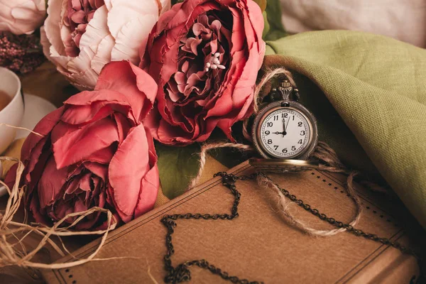 Nota di carta artigianale con tazza di tè, fiori, peonie, vecchio orologio d'epoca. Fondo retrò . — Foto Stock