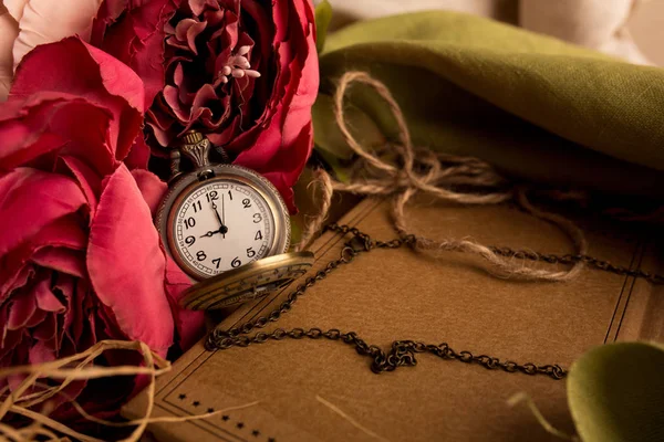 Craft paper note with cup of tea, flowers, peonies, old vintage clock. Retro background.