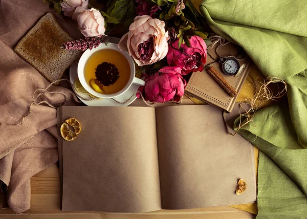 Nota de papel artesanal con taza de té, flores, peonías, viejo reloj vintage. Fondo retro . — Foto de Stock