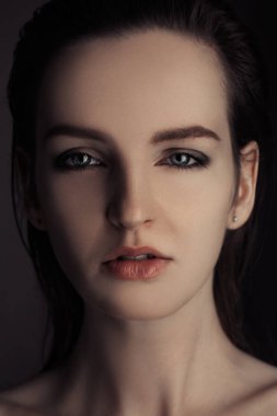 Gri arka plan üzerinde izole bir güzel kız stüdyo portresi. doğal cilt. genç kadın uzun kahverengi saçlı siyah keten Studio poz. Seksi model