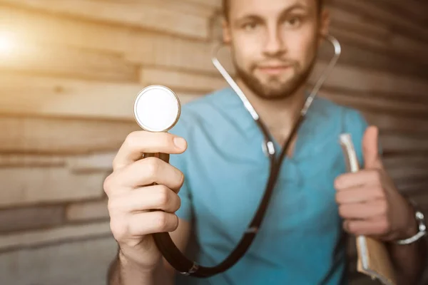 Médico de medicina masculina inteligente toma estetoscópio. Radiologia, conceito terapêutico. Conceito de assistência médica ou seguro. Estagiário em casaco azul leva fonendos — Fotografia de Stock