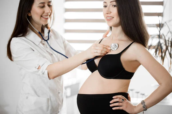 Ženské lékařství doktor hospodářství stetoskop na těhotnou ženu stojící za povzbuzení, empatie, fandění, podporu, lékařské vyšetření. Nový život potrat koncepce. — Stock fotografie