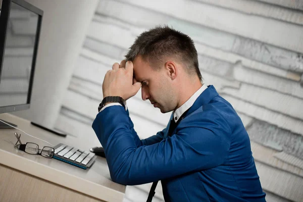 Κουρασμένος επιχειρηματίας στο χώρο εργασίας στο γραφείο κρατώντας το κεφάλι του στα χέρια. Εργαζόμενος υπνηλία το πρωί μετά τη δουλειά αργά το βράδυ. Υπερβολικές ώρες εργασίας, κάνοντας λάθος, άγχος, λήξη ή κατάθλιψη έννοια Φωτογραφία Αρχείου