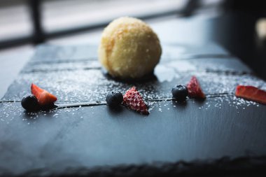 Kızarmış dondurma sosu ve pencerenin önünde siyah taş plaka üzerinde meyve ile Hindistan cevizi içinde. Asya gıda arka plan. Beslenme kavramı. Ahşap masa ile Restaraunt yer. Kopya alanı için metin, tasarım.