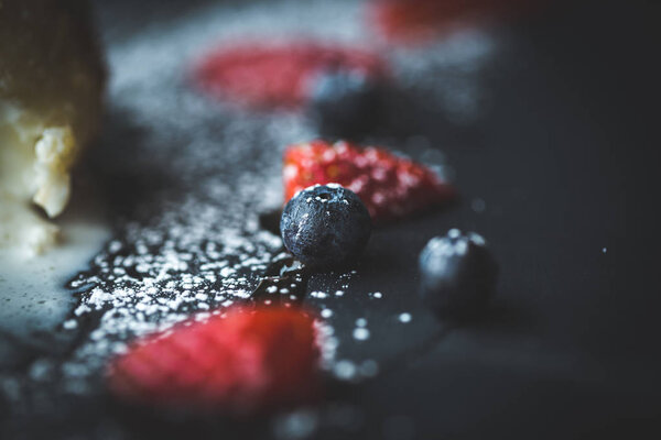 Macro photo of strawberry and Blueberries on slate plate with coconut background. Food concept. Red summer fruits. Close up object. Flare copy space for text, design