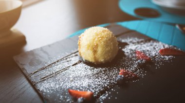 Izgara-dondurmanın içine Hindistan cevizi soslu siyah taş plaka üzerinde. Asya gıda arka plan. Beslenme kavramı. Ahşap masa ile restoran yer. Metin, tasarım için kopya yer flare. 16 9 ürün