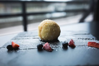 Izgara-dondurmanın içine Hindistan cevizi soslu siyah taş plaka üzerinde. Asya gıda arka plan. Beslenme kavramı. Ahşap masa ile restoran yer. Kopya alanı için metin, tasarım.