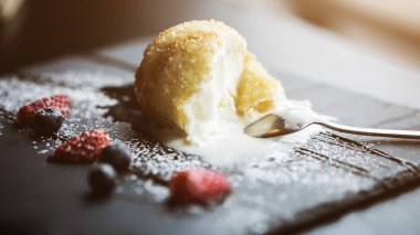 Izgara-dondurmanın içine Hindistan cevizi soslu siyah taş plaka üzerinde. Asya gıda arka plan. Beslenme kavramı. Ahşap masa ile restoran yer. Metin, tasarım için kopya yer flare. 16 9 ürün