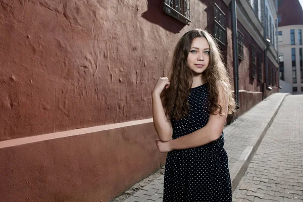 Linda morena jovem vestindo vestido e andando na rua. Flare para texto e design. Estilo de vida na cidade . — Fotografia de Stock