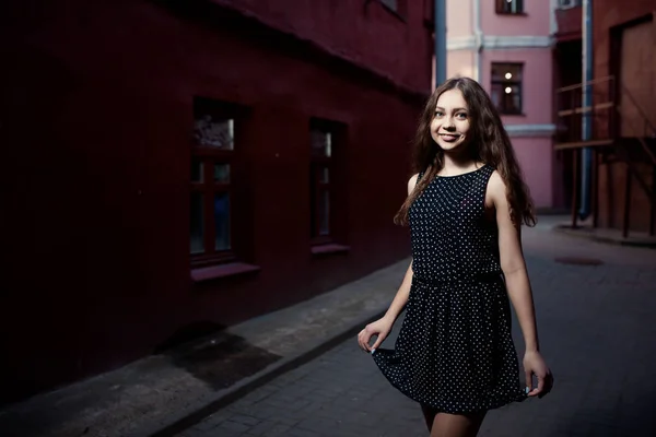 Beautiful brunette young woman wearing dress and walking on the street. Flare for text and design. Lifestyle in the city. — Stock Photo, Image