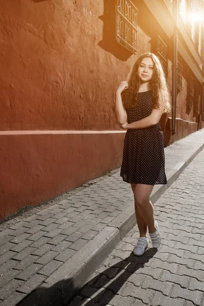 美丽黑发的年轻女人穿的衣服，走在大街上。文本和设计的火炬。在城市的生活方式. — 图库照片