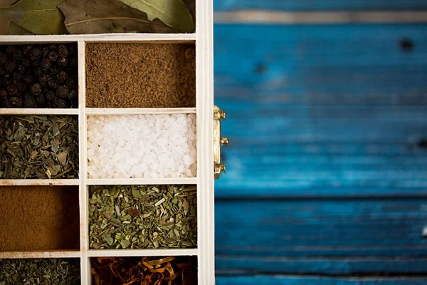 Especias en caja de madera sobre fondo azul. Copia espacio para texto y diseño. Concepto alimenticio — Foto de Stock