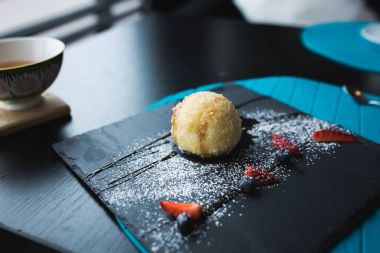 Izgara-dondurmanın içine Hindistan cevizi soslu siyah taş plaka üzerinde. Asya gıda arka plan. Beslenme kavramı. Ahşap masa ile restoran yer. Kopya alanı için metin, tasarım.