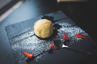 Izgara-dondurmanın içine Hindistan cevizi soslu siyah taş plaka üzerinde. Asya gıda arka plan. Beslenme kavramı. Ahşap masa ile restoran yer. Kopya alanı için metin, tasarım.