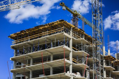 İnşaat kavramı. Gökyüzü inşaat altında yeni bir yapı. Mavi arka plan. Yeni Kentsel şehir. Makine, vinçler ve İskele inşaatçılar. Ağır sanayi ve iş güvenliği