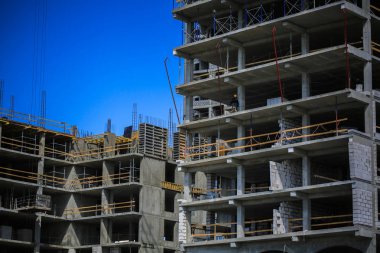 İnşaat kavramı. Gökyüzü inşaat altında yeni bir yapı. Mavi arka plan. Yeni Kentsel şehir. Makine, vinçler ve İskele inşaatçılar. Ağır sanayi ve iş güvenliği