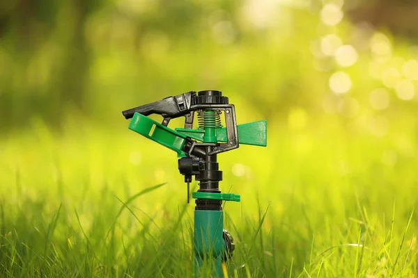 Plastic garden splinkter standing on the groud in the gazon grass. — Stock Photo, Image